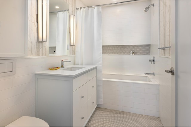 bathroom featuring toilet, vanity, tile patterned floors, and tiled shower / bath