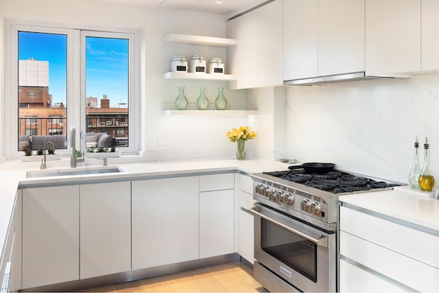 7 W 96th St Pha, Pha, New York City, NY 10025 - kitchen with high end range, open shelves, light countertops, white cabinetry, and under cabinet range hood