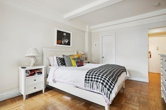 bedroom featuring baseboards and beam ceiling