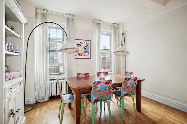 dining room featuring radiator heating unit, a wealth of natural light, and cooling unit