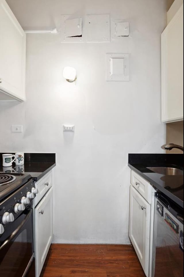 kitchen featuring dark countertops, dishwashing machine, range, and a sink