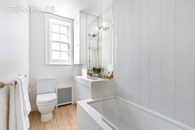 full bath with shower / washtub combination, wood finished floors, visible vents, toilet, and vanity