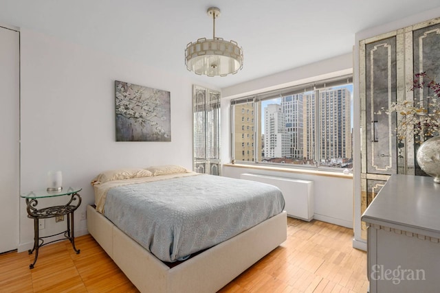 bedroom with radiator and light wood-style floors