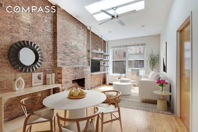 304 W 88th St Unit 4B, New York City, NY 10024 - dining room with a skylight, wood finished floors, ceiling fan, a brick fireplace, and brick wall