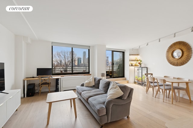 living room with visible vents, rail lighting, and light wood-style flooring
