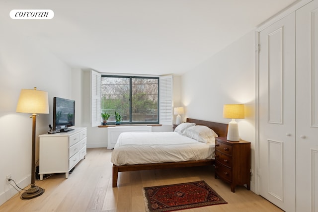 bedroom featuring baseboards, visible vents, and light wood finished floors