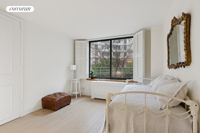 bedroom with baseboards, visible vents, and wood finished floors