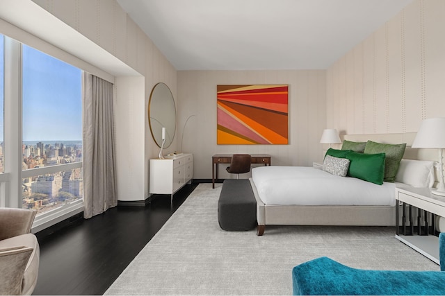 bedroom with wallpapered walls and wood finished floors