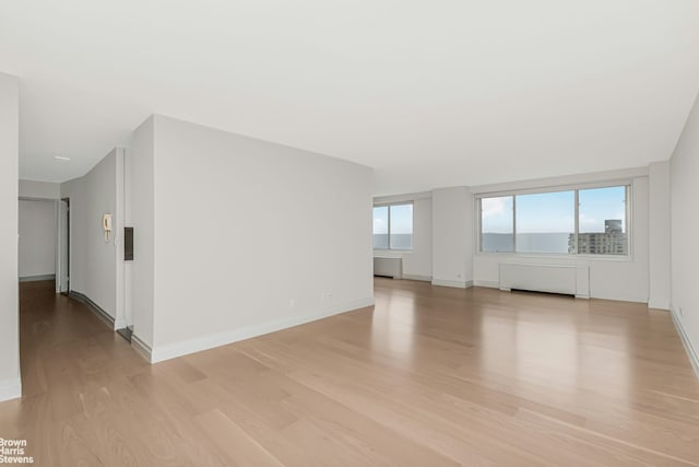 empty room with baseboards and light wood-type flooring