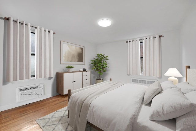 bedroom featuring wood finished floors and radiator