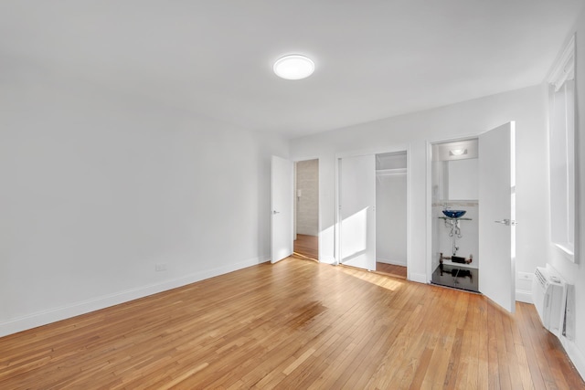 unfurnished bedroom with light wood-type flooring, a closet, and baseboards
