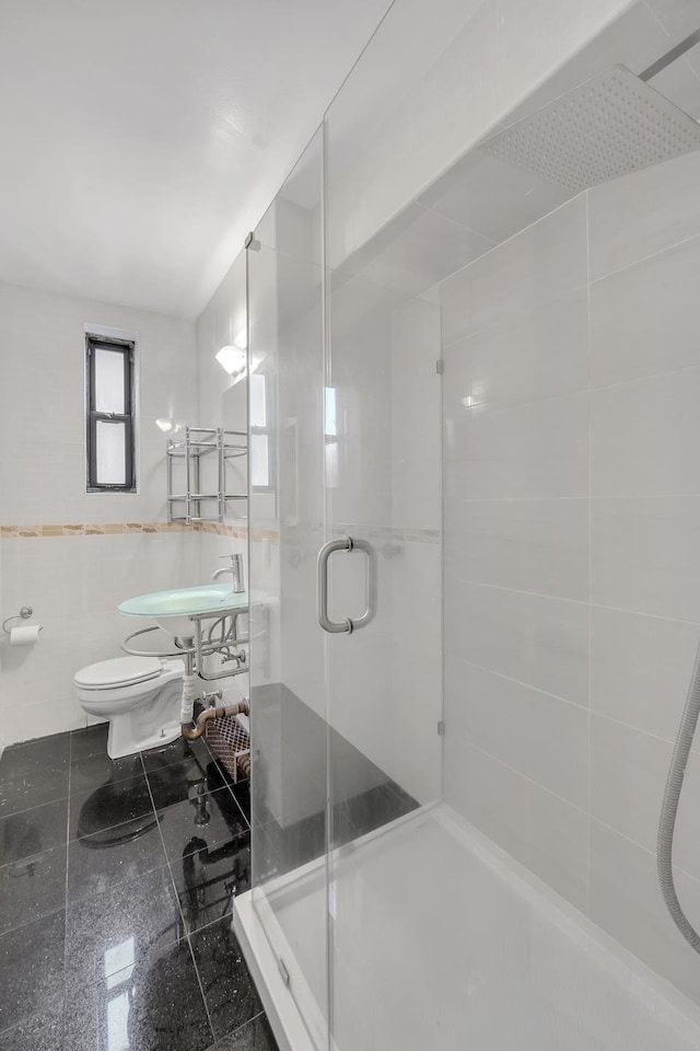 full bath with toilet, a shower stall, and tile walls