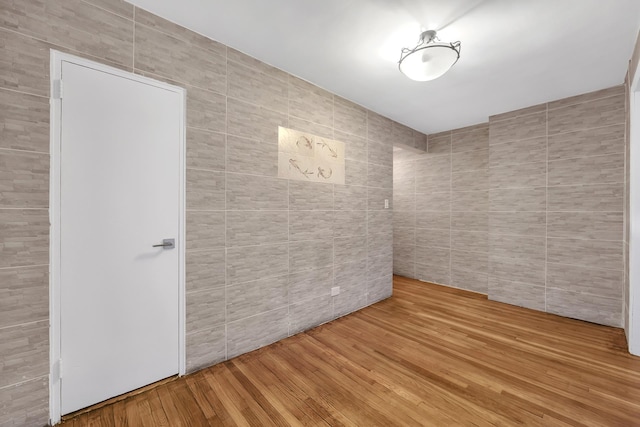 345 Webster Ave Unit 3N, New York City, NY 11230 - spare room featuring tile walls and wood finished floors