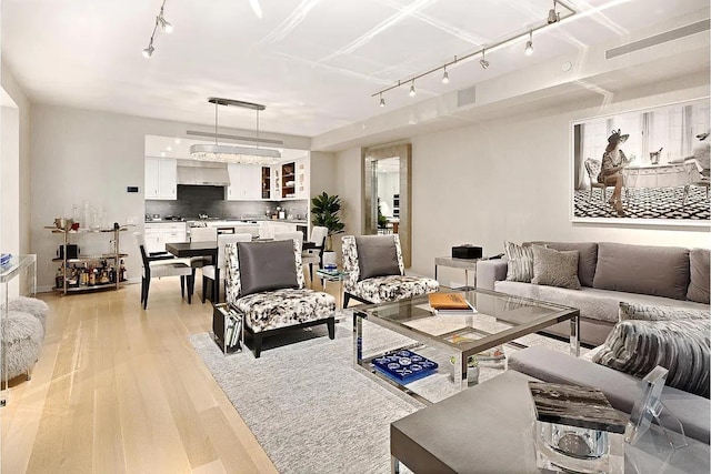 living area featuring visible vents, track lighting, and light wood-style flooring