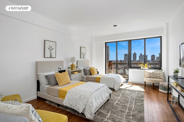 bedroom with wood-type flooring and baseboards
