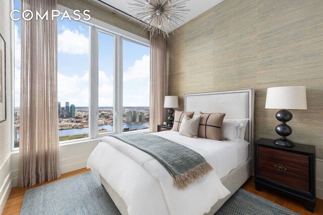 252 E 57th St Unit 60A, New York City, NY 10022 - bedroom with a water view, multiple windows, wood finished floors, and baseboards