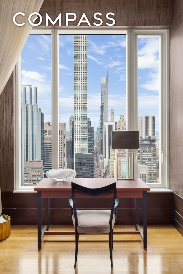 252 E 57th St Unit 60A, New York City, NY 10022 - dining room featuring wood finished floors, a skyline view, and plenty of natural light