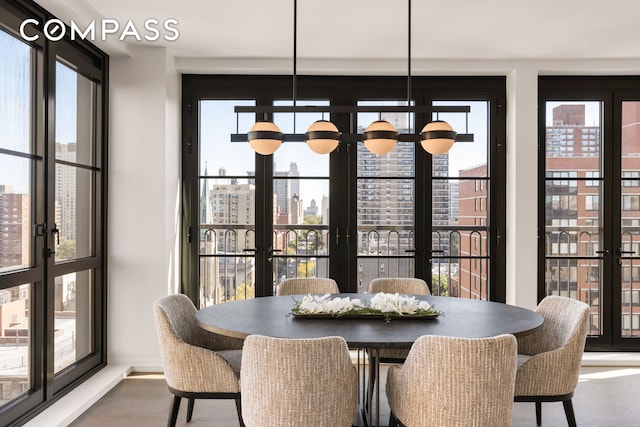 dining space with a chandelier, a city view, wood finished floors, and plenty of natural light