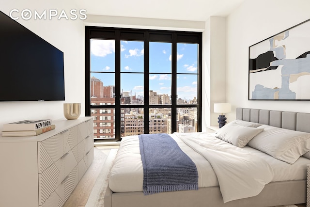 bedroom with multiple windows and light wood-style flooring