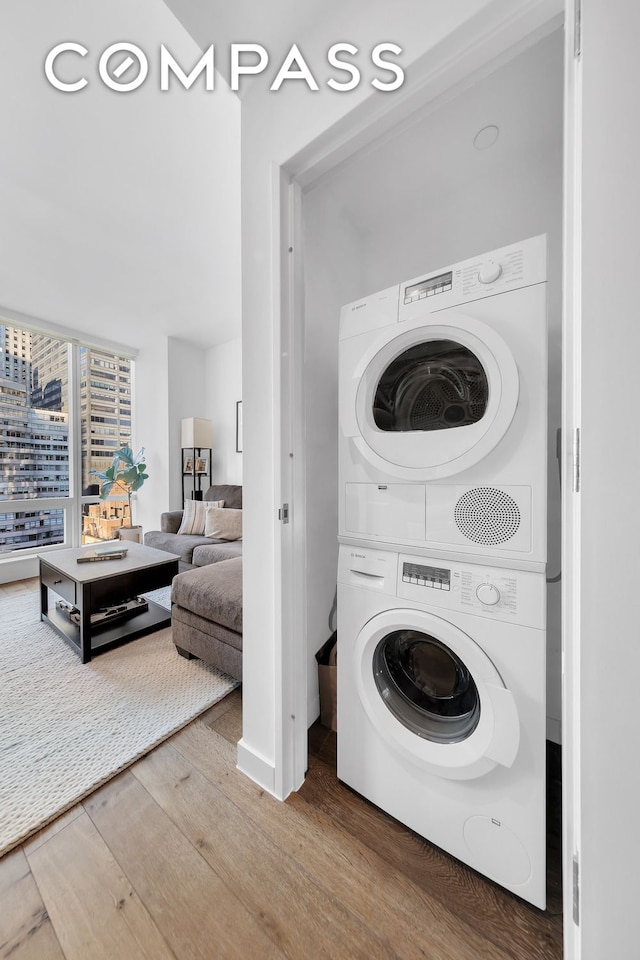 325 Lexington Ave Unit 16C, New York City, NY 10016 - washroom featuring estacked washer and dryer and wood finished floors