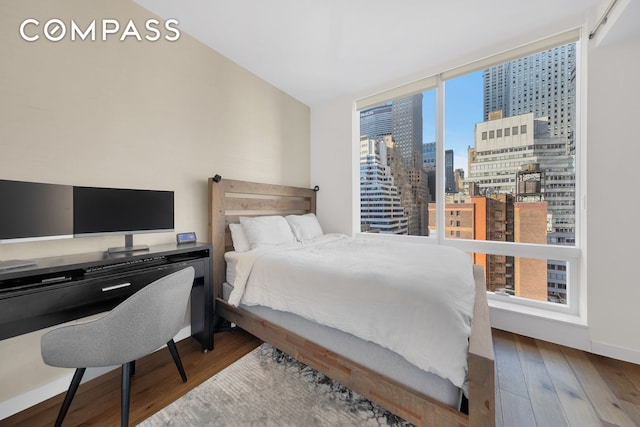 325 Lexington Ave Unit 16C, New York City, NY 10016 - bedroom with a view of skyline and wood-type flooring