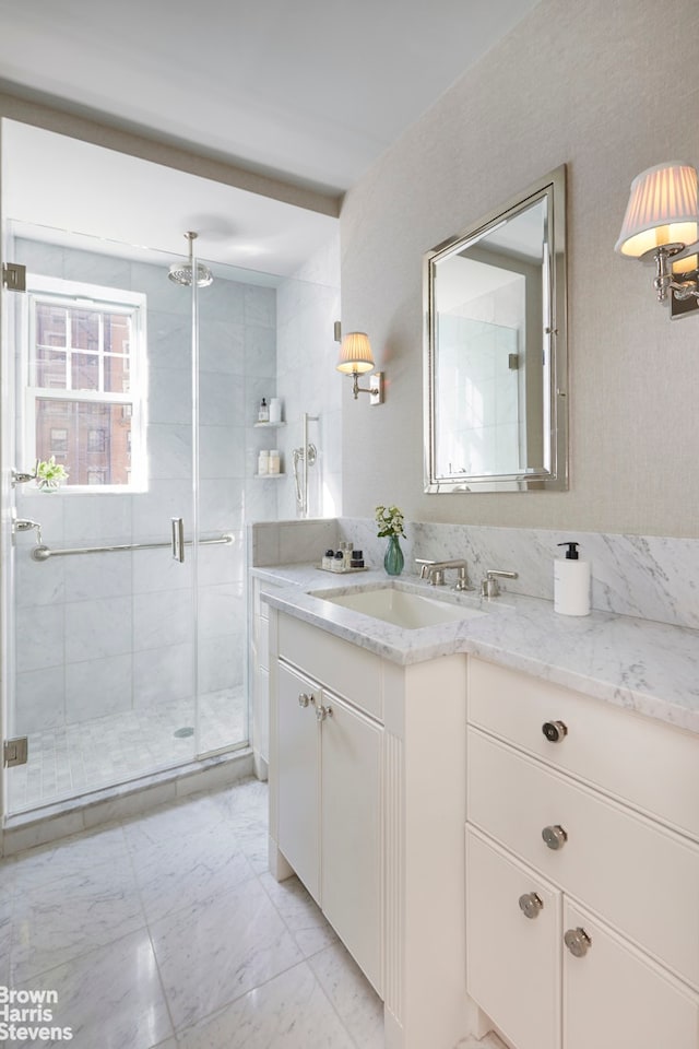 bathroom featuring marble finish floor, vanity, and a stall shower