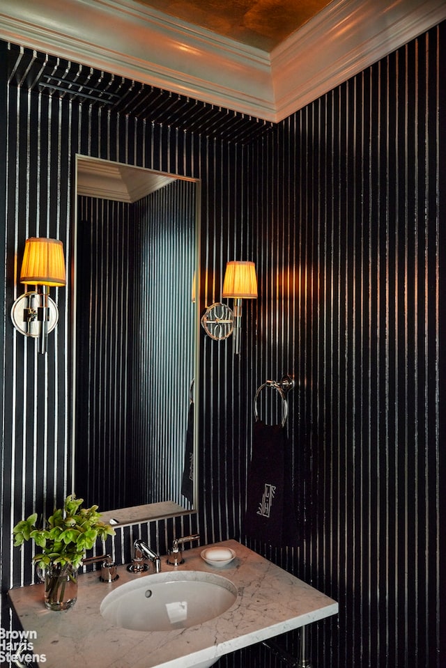 bathroom featuring a sink and crown molding