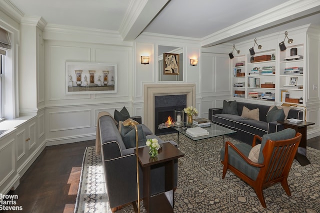living area featuring a warm lit fireplace, a decorative wall, and crown molding