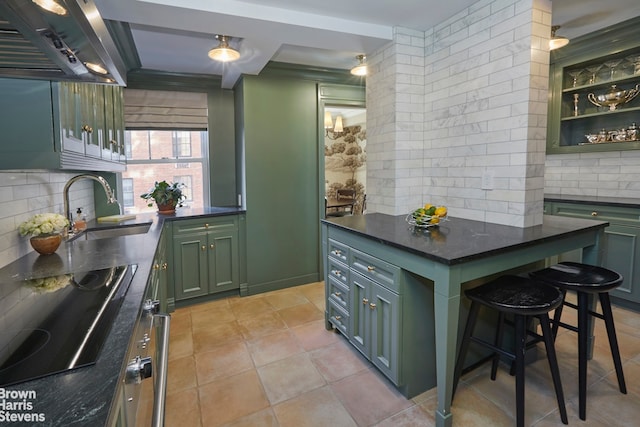 kitchen with backsplash, green cabinetry, black electric stovetop, and a sink