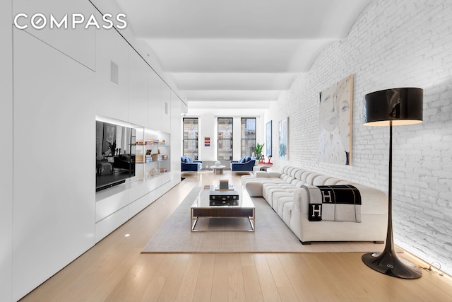 living room with light wood-type flooring and brick wall