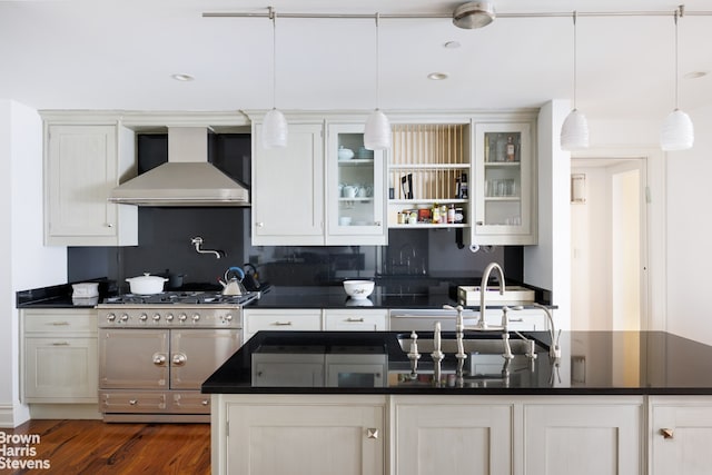 535 W End Ave Unit 8B, New York City, NY 10024 - kitchen with wall chimney range hood, double oven range, dark countertops, a center island with sink, and recessed lighting