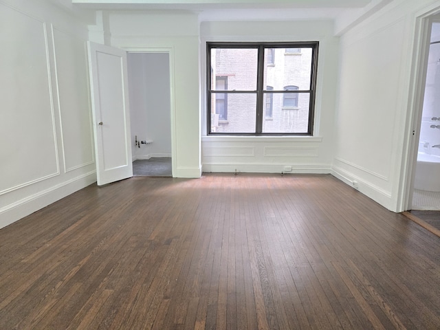 162 W 56th St Unit 1101, New York City, NY 10019 - spare room featuring dark wood-type flooring and a decorative wall