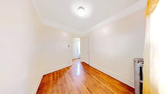 spare room featuring baseboards and wood finished floors