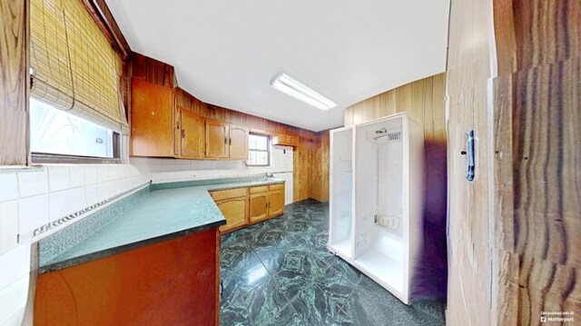 kitchen featuring brown cabinets and wood walls