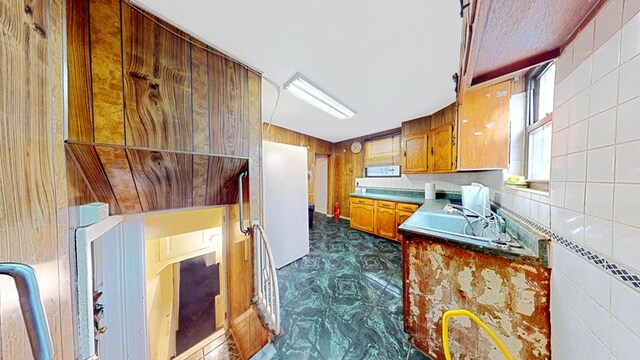 kitchen with brown cabinetry and freestanding refrigerator