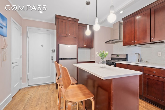 61 Oliver St Unit 4P, New York City, NY 11209 - kitchen featuring wall chimney range hood, appliances with stainless steel finishes, crown molding, decorative backsplash, and light wood-type flooring