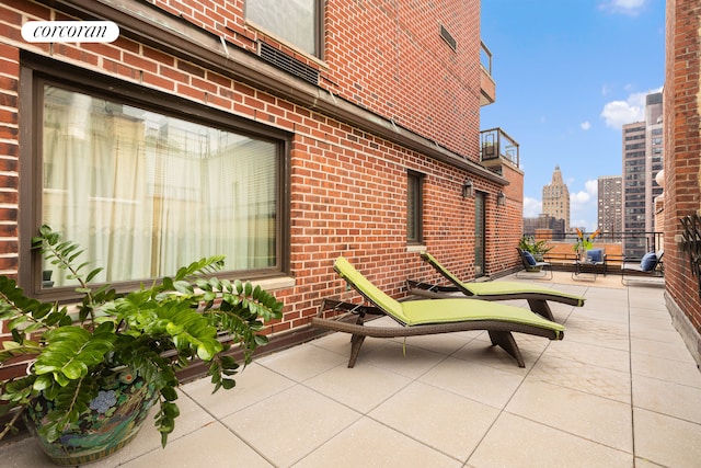 view of patio with a balcony and a view of city