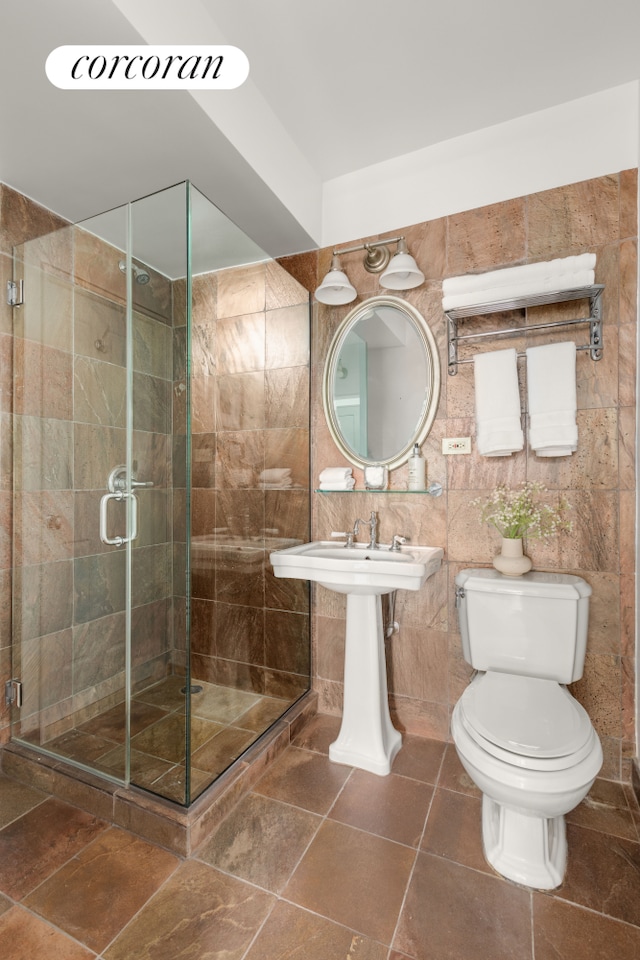 full bathroom with a stall shower, toilet, and tile patterned flooring