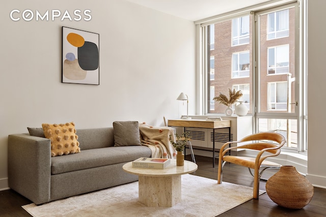 sitting room featuring plenty of natural light, wood finished floors, and baseboards