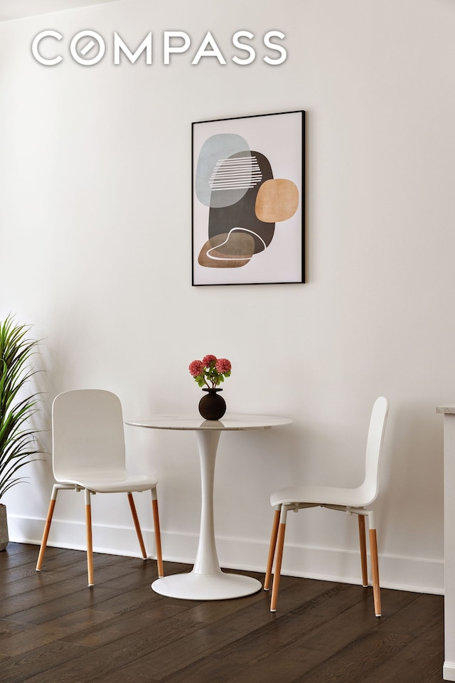 dining space with dark wood-style flooring and baseboards