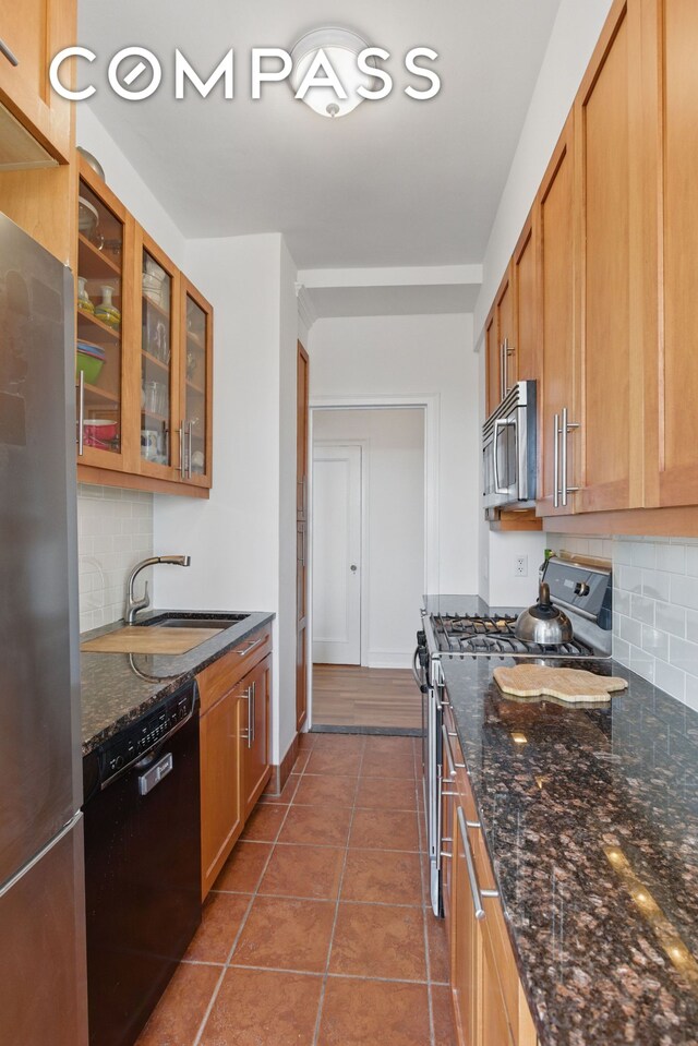 1 Plaza St W Unit 12C, New York City, NY 11217 - kitchen with stainless steel appliances, decorative backsplash, a sink, and glass insert cabinets