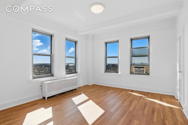 1 Plaza St W Unit 12C, New York City, NY 11217 - spare room featuring radiator heating unit, cooling unit, wood finished floors, and baseboards