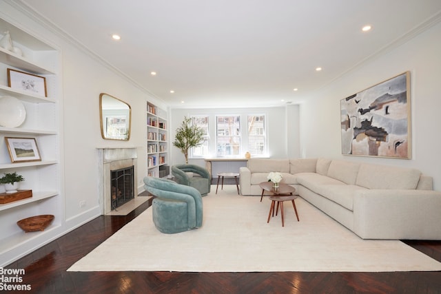 117 E 72nd St Unit 2W, New York City, NY 10021 - living area with a high end fireplace, built in shelves, recessed lighting, crown molding, and baseboards