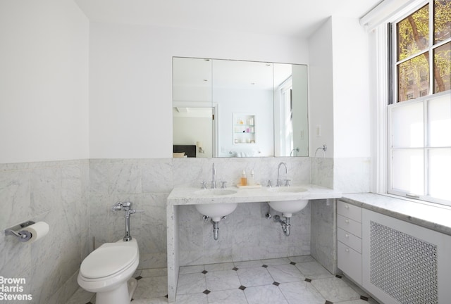 117 E 72nd St Unit 2W, New York City, NY 10021 - bathroom featuring plenty of natural light, tile walls, toilet, tile patterned floors, and radiator