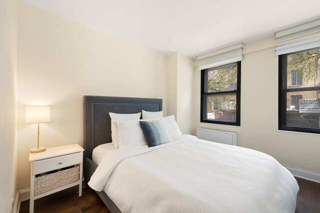 200 E 27th St Unit 2J, New York City, NY 10016 - bedroom with dark wood-style floors, multiple windows, and baseboards