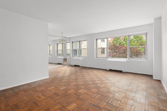 20 E 9th St Unit 2X, New York City, NY 10003 - unfurnished room featuring radiator heating unit and a chandelier