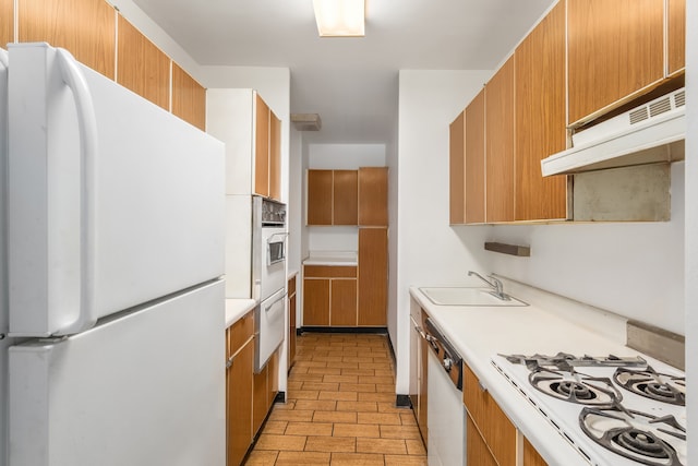 20 E 9th St Unit 2X, New York City, NY 10003 - kitchen with white appliances, under cabinet range hood, light countertops, a warming drawer, and brown cabinets