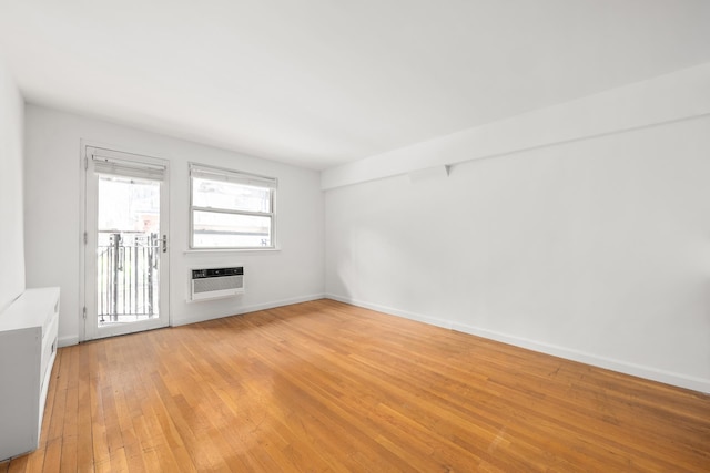 211 Thompson St Unit Lb, New York City, NY 10012 - empty room with an AC wall unit, light wood-style flooring, and baseboards