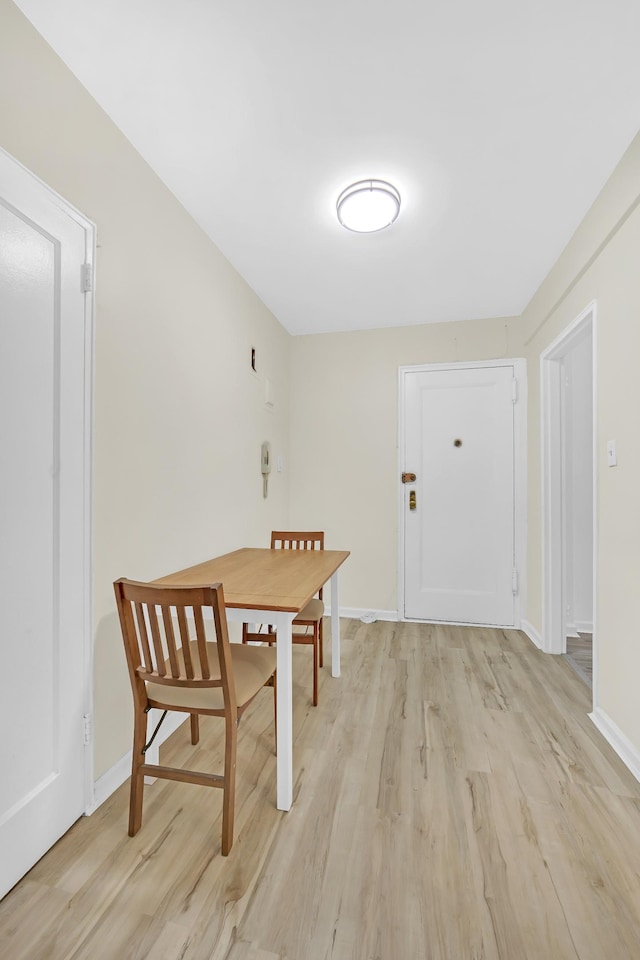 unfurnished dining area with baseboards and light wood-style floors
