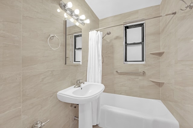full bath featuring tile walls and shower / tub combo with curtain